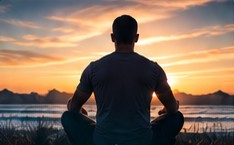 Person meditating at sunset